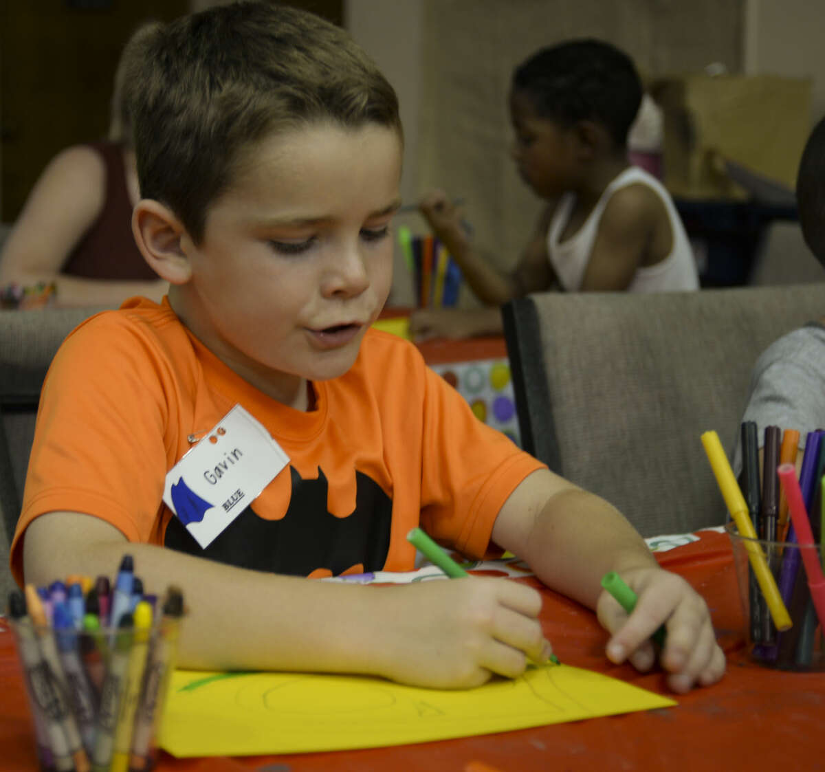 Gavin and others color their super hero shields Wednesday 7-8-15, during crafts at We Are the World Camp. Tim Fischer\Reporter-Telegram