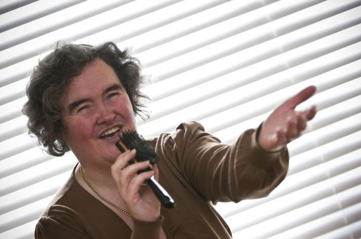 FILE - In this April 16, 2009 file photo, Susan Boyle, whose performance on the television show "Britain's Got Talent" wowed the judges, poses singing with a hairbrush at her home in Blackburn, Scotland. But what happened next for Susan Boyle? The middle-aged church volunteer from a small town in Scotland became an instant global celebrity in 2009 with her heart-stopping rendition of the "Les Miserables" number "I Dreamed a Dream" on a TV talent show. A week is a long time in showbiz _ and in our hyper-speed online age three and a half years is an eternity _ but Boyle is still going strong. She has sold millions of records, received an honorary doctorate, sung for Pope Benedict XVI and performed in Las Vegas. A stage musical about her life has played to enthusiastic crowds across Britain and is headed for Australia, and next month she releases her fourth album, "Standing Ovation." (AP Photo, File)