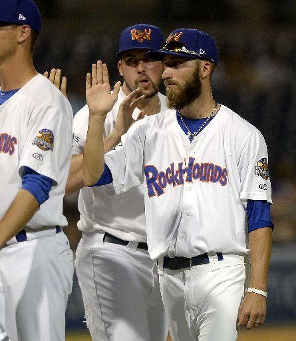 Rockhounds pitcher Dillon Overton high-fives teammates after a win against San Antonio on Thursday, July 23, 2015 at Security Bank Ballpark.