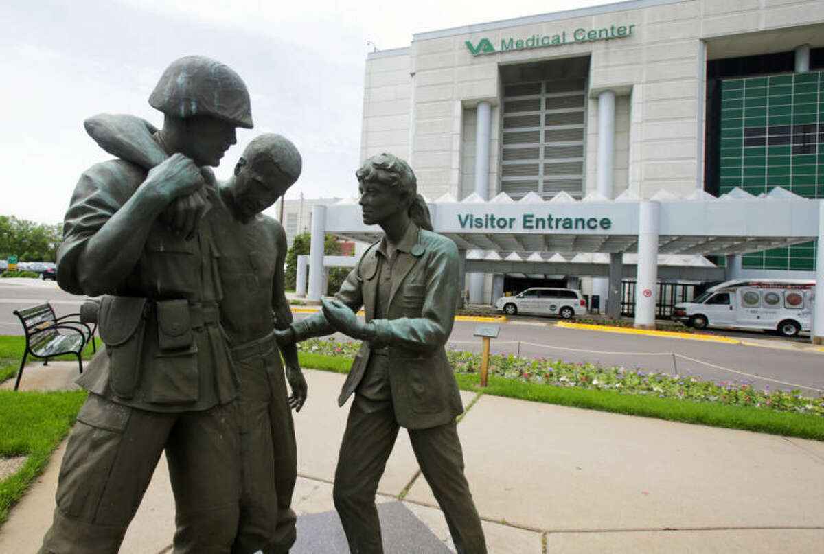 Three statues portraying a wounded soldier being helped, stand on the grounds of the Minneapolis VA Hospital, Monday, June 9, 2014. An audit of 731 VA hospitals and clinics found that a 14-day goal for seeing first-time patients was unattainable given increasing demand for health care. The VA said Monday it was abandoning the scheduling goal. (AP Photo/Jim Mone)