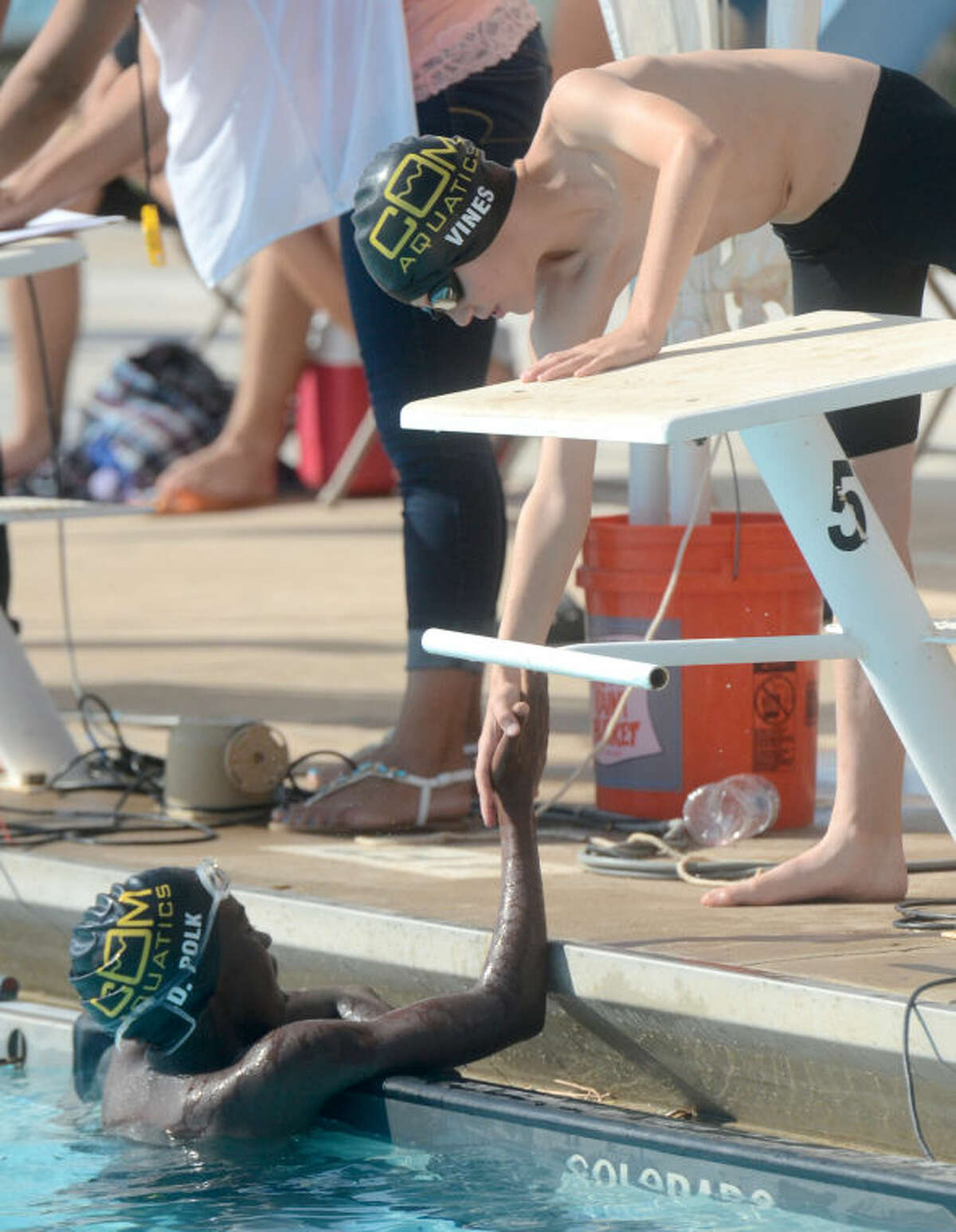 D'Avante Polk of COM is congratulated by a teammate after taking first place in the Boys 11-12 400 Free event during the 69th annual Frost Bank Invitational on Thursday at Doug Russell Pool. James Durbin/Reporter-Telegram