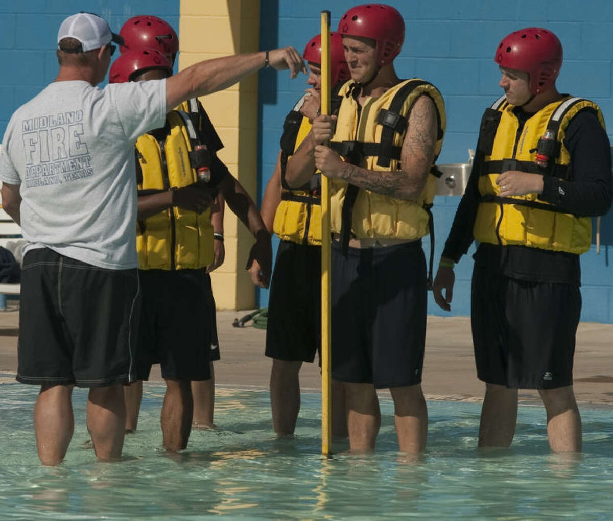 MFD firefighter Rusty Welch works with recruits on safety measures during water rescues Thursday at Washington Pool. Tim Fischer\Reporter-Telegram