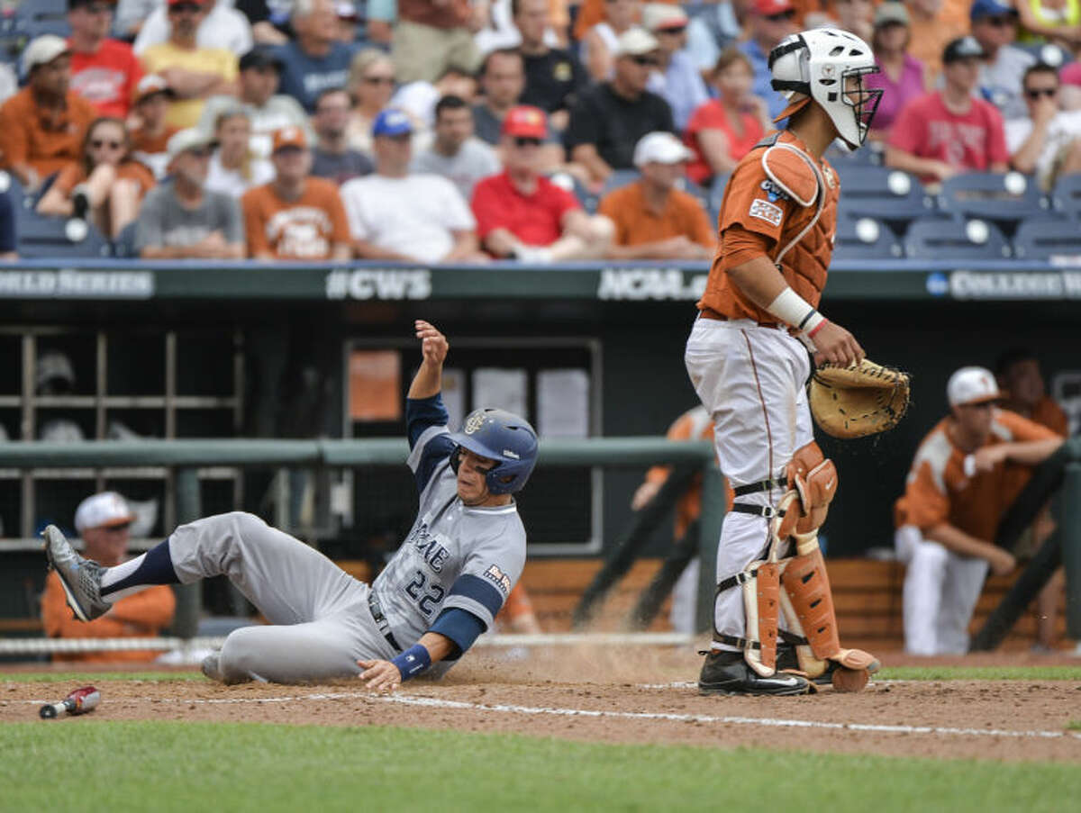 UC Irvine shortstop Chris Rabago (22) scores on a single by Jonathan Munoz in the eighth inning of an NCAA baseball College World Series game against Texas in Omaha, Neb., on Saturday. At right is Texas catcher Tres Barrera. (AP Photo/Ted Kirk)