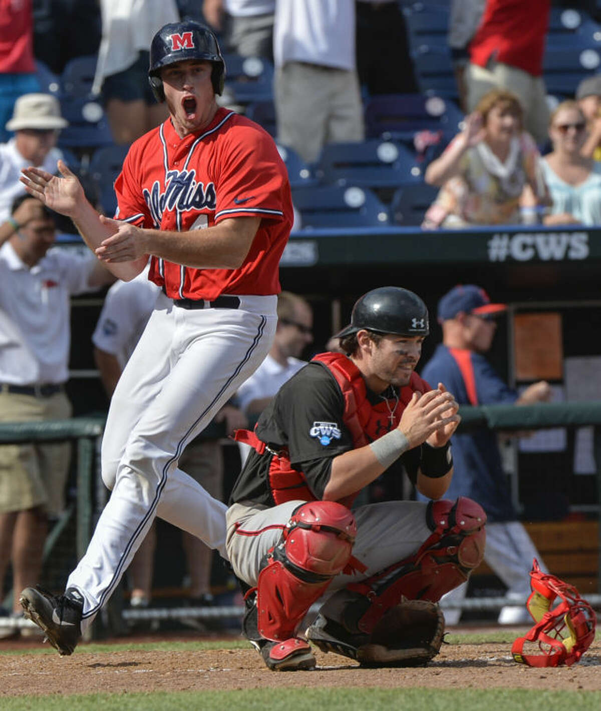 Mississippi's Aaron Greenwood, who scored the winning run against Texas Tech on a single by John Gatlin, celebrates left, as Texas Tech catcher Hunter Redman (5) crouches dejected, following an NCAA baseball College World Series elimination game in Omaha, Neb., Tuesday, June 17, 2014. (AP Photo/Ted Kirk)