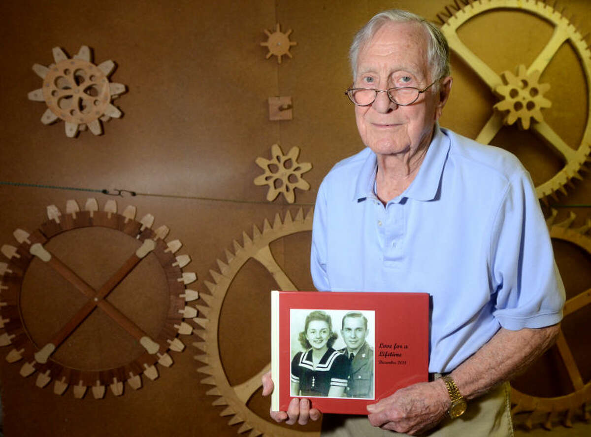 John Crosby - World War II veteran - John Crosby poses with some handmade clock gears he built holding a photo album depicting his late wife, Mary, on Thursday at his home. James Durbin/Reporter-Telegram
