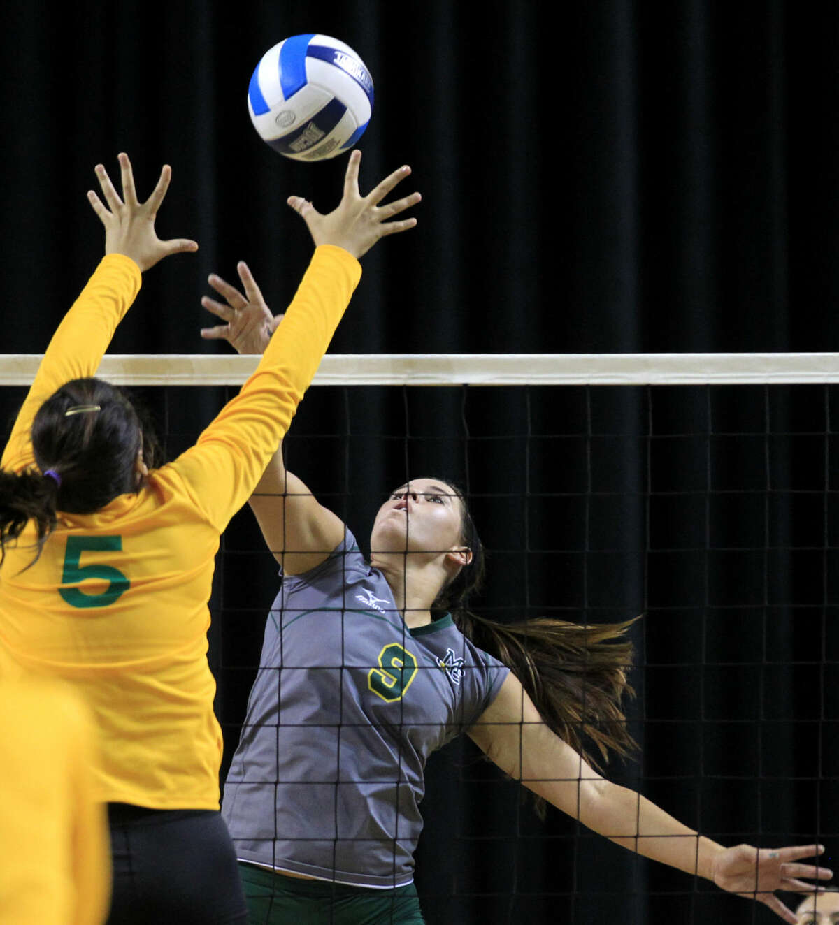Midland College's Shelby Bartley (9) hits against Laredo's Stephanie Perez (5) on Saturday, Aug. 23, 2014 at Chaparral Center. James Durbin/Reporter-Telegram