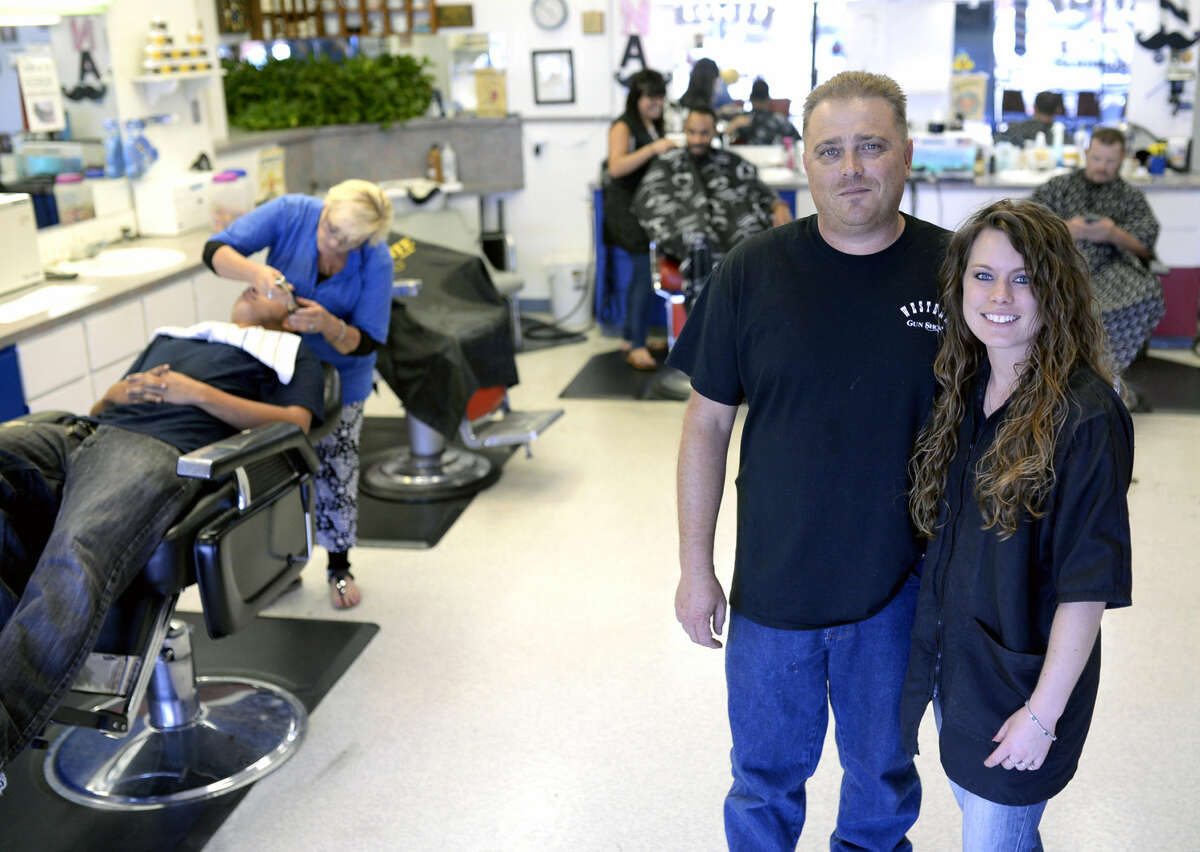 Co-owners Chris and Jennifer Hodge in portrait at the Western Barber and Gun Store on Wednesday, August 19, 2015. The barbershop occupies the front of the storefront and the gun shop is tucked into a small room near the back. James Durbin/Reporter-Telegram