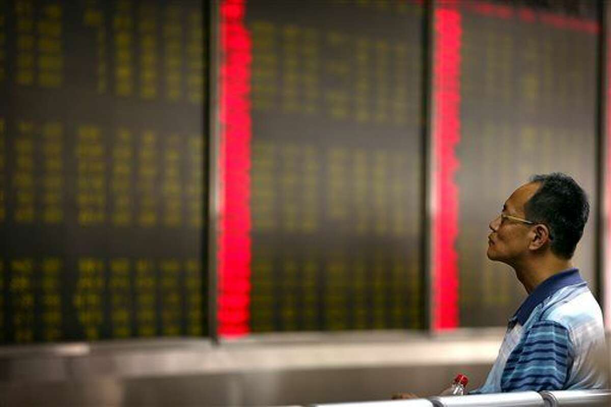 A Chinese investor monitors stock prices at a brokerage house in Beijing, Monday, Aug. 24, 2015. Stocks tumbled across Asia on Monday as investors shaken by the sell-off last week on Wall Street unloaded shares in practically every sector. (AP Photo/Mark Schiefelbein)