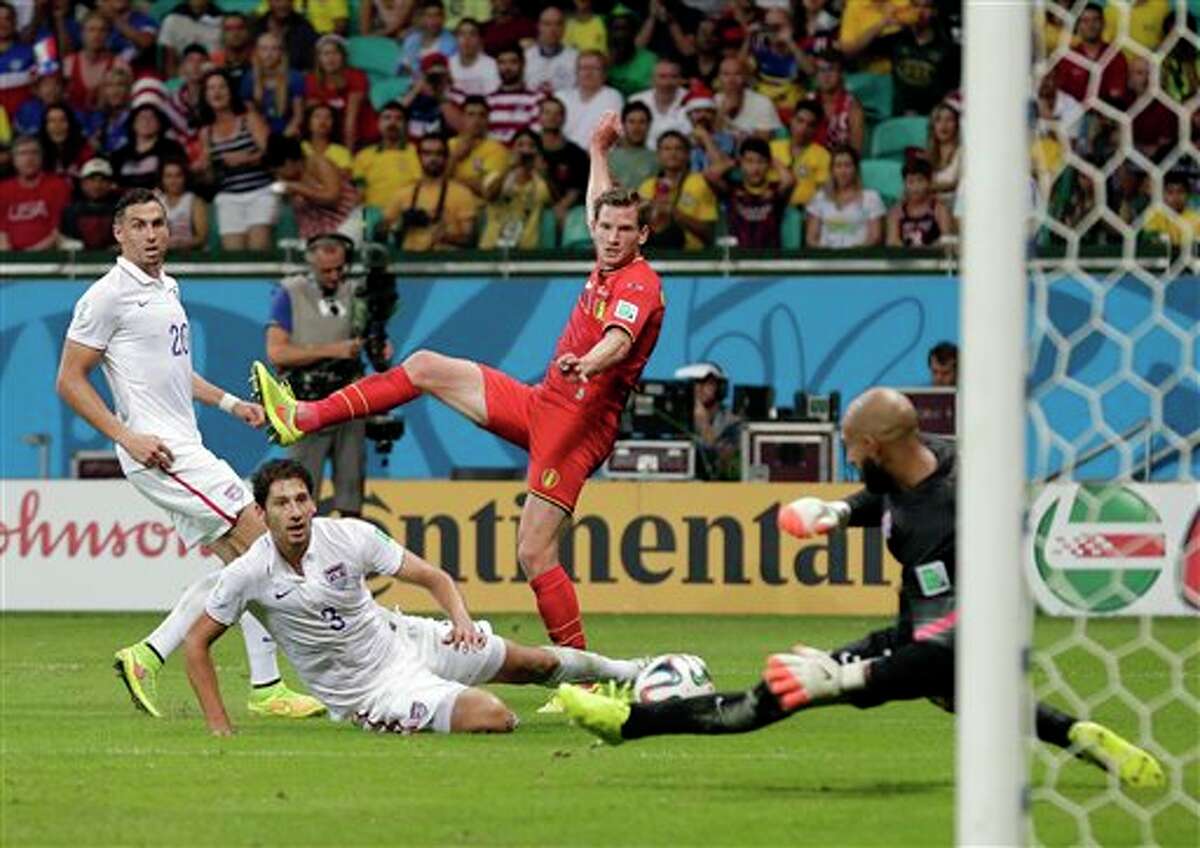 United States' Omar Gonzalez (3) and Geoff Cameron (20) watch as goalkeeper Tim Howard makes a save on Belgium's Jan Vertonghen shot on goal during the World Cup round of 16 soccer match between Belgium and the USA at the Arena Fonte Nova in Salvador, Brazil, Tuesday, July 1, 2014. (AP Photo/Marcio Jose Sanchez)