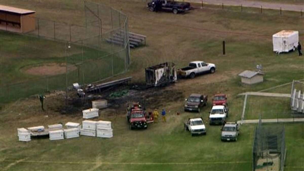 This photo from video provided by WFAA-TV in Dallas shows the aftermath of a fireworks explosion in Comanche, Texas, Thursday, July 3, 2014. A trailer loaded with fireworks exploded near a Texas high school, killing one person and injuring three other people who were setting up for a Fourth of July show. It's unclear what triggered the explosion, which occurred near a baseball field adjacent to the high school in Comanche, about 100 miles southwest of Fort Worth. The trailer was hooked to a pickup truck.(AP Photo/WFAA-TV) TELEVISION OUT