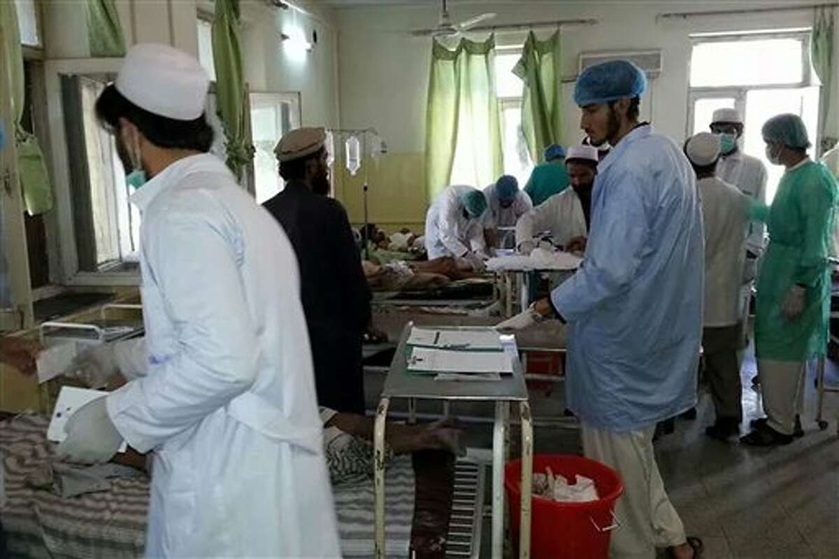 Afghan doctors assist civilians who were wounded when a suicide bomber detonated his explosives-packed vehicle near a crowded market and a mosque, in the main hospital in Sharan, capital of Paktika province, Afghanistan, Tuesday, July 15, 2014. An Afghan general said scores of people were killed and over 40 wounded in a bombing in the country's eastern Paktika province. He said the military is providing helicopters and ambulances to transport the victims to the provincial capital, Sharan. Taliban sent a statement to media denying their involvement in the attack. (AP Photo)