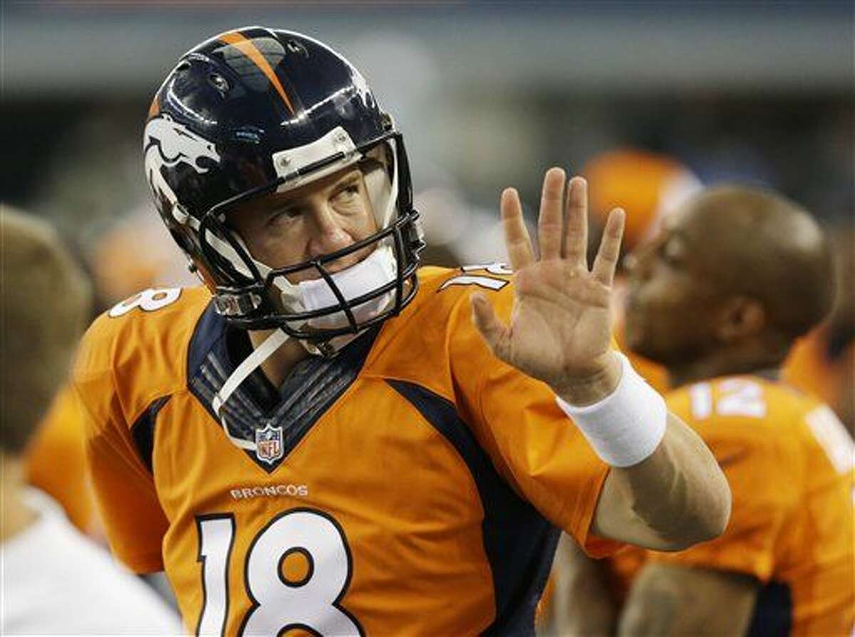 Denver Broncos quarterback Peyton Manning (18) waves to a fan in the first half of a NFL preseason football game against the Dallas Cowboys, Thursday, Aug. 28. 2014, in Arlington, Texas. (AP Photo/LM Otero)