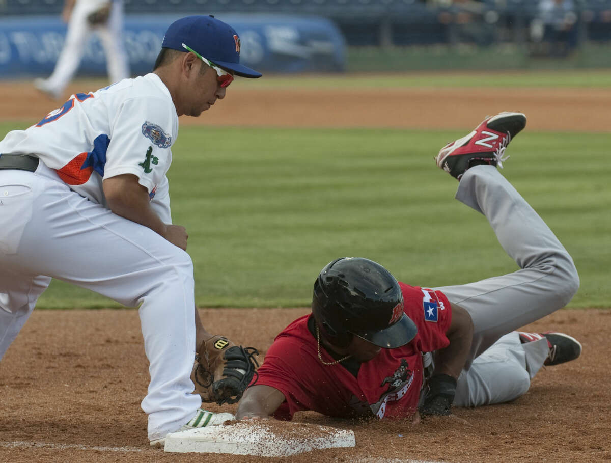 RockHounds first baseman Hiro Nakajima attempts to make the tag on a pickoff but RoughRiders' Nick Williams beats the throw Monday at Security Bank Balpark. Tim Fischer\Reporter-Telegram