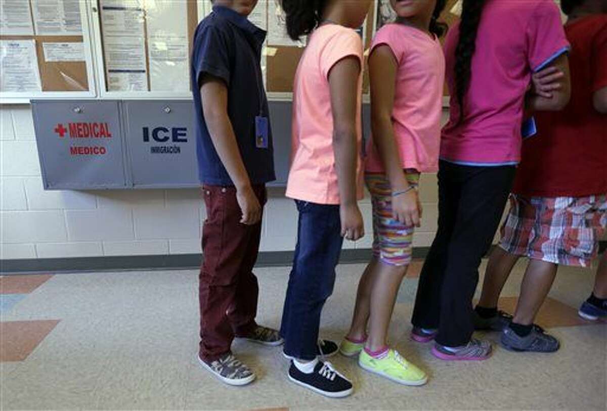 Detained immigrant children line up in the cafeteria at the Karnes County Residential Center, a temporary home for immigrant women and children detained at the border, Wednesday, Sept. 10, 2014, in Karnes City, Texas. Federal authorities want to build a similar immigration lockup facility for families in Dilley, Texas, south of San Antonio amid an unprecedented surge in the number of youngsters pouring across the U.S. border, a federal official said Thursday. (AP Photo/Eric Gay)