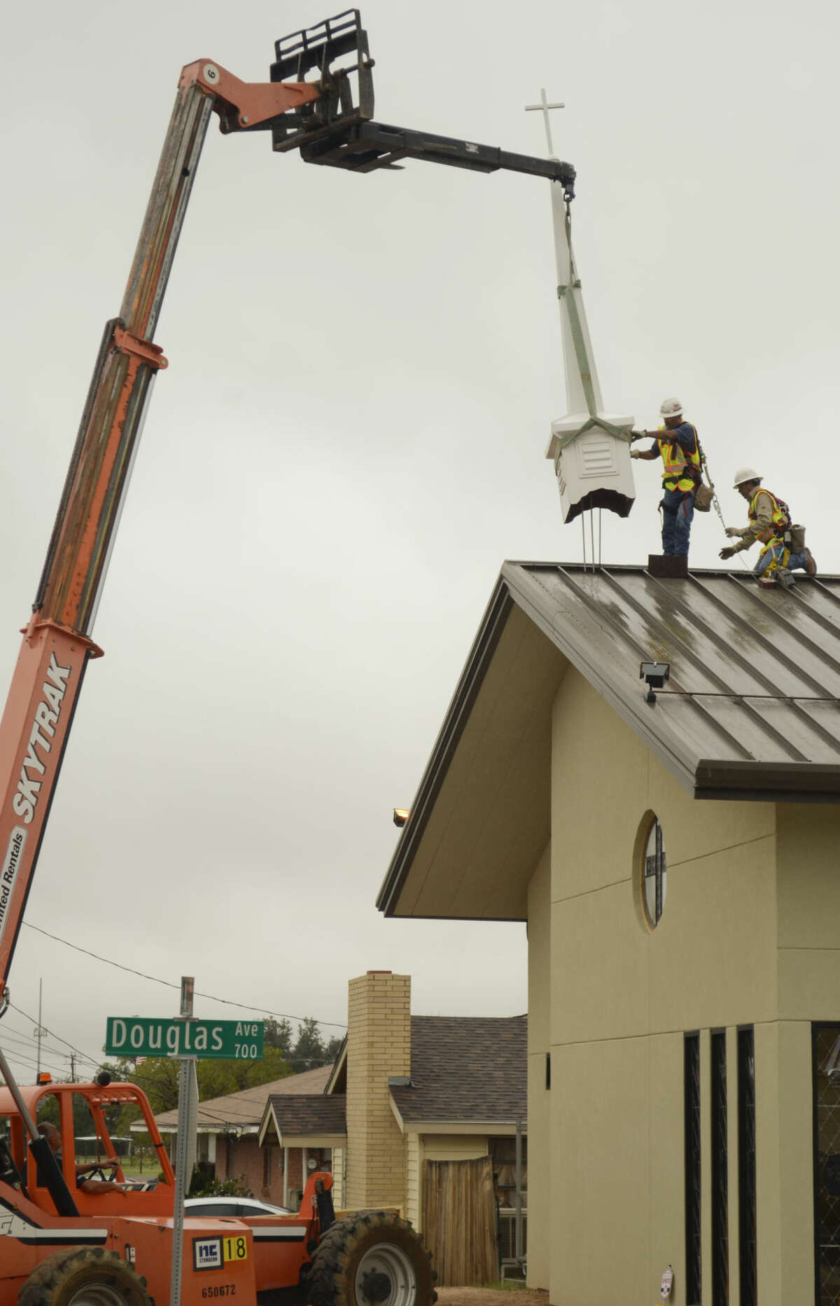 Workers prepare the steeple as they work to place it on top of the new St. Paul's Anglican Church building Friday morning. Tim Fischer\Reporter-Telegram