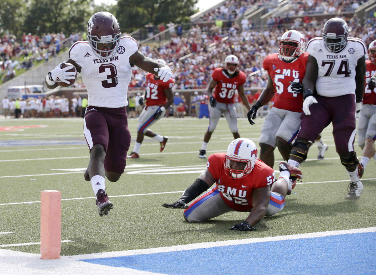 Texas A&M running back Trey Williams (3) high steps into the end zone past SMU linebacker Cameron Nwosu (52) as the Aggies' Germain Ifedi (74) watches in the first half of an NCAA college football game, Saturday, Sept. 20, 2014, in Dallas. (AP Photo/Tony Gutierrez)