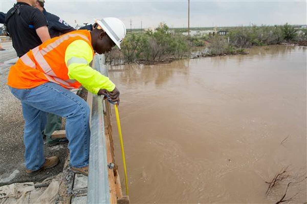 A employee from the Texas Department of Transpiration measures the depth of the Pecos River in Ward County, Texas, between Pecos and Barstow on Monday, Sept. 22, 2014. (AP Photo/The Odessa American, Courtney Sacco)
