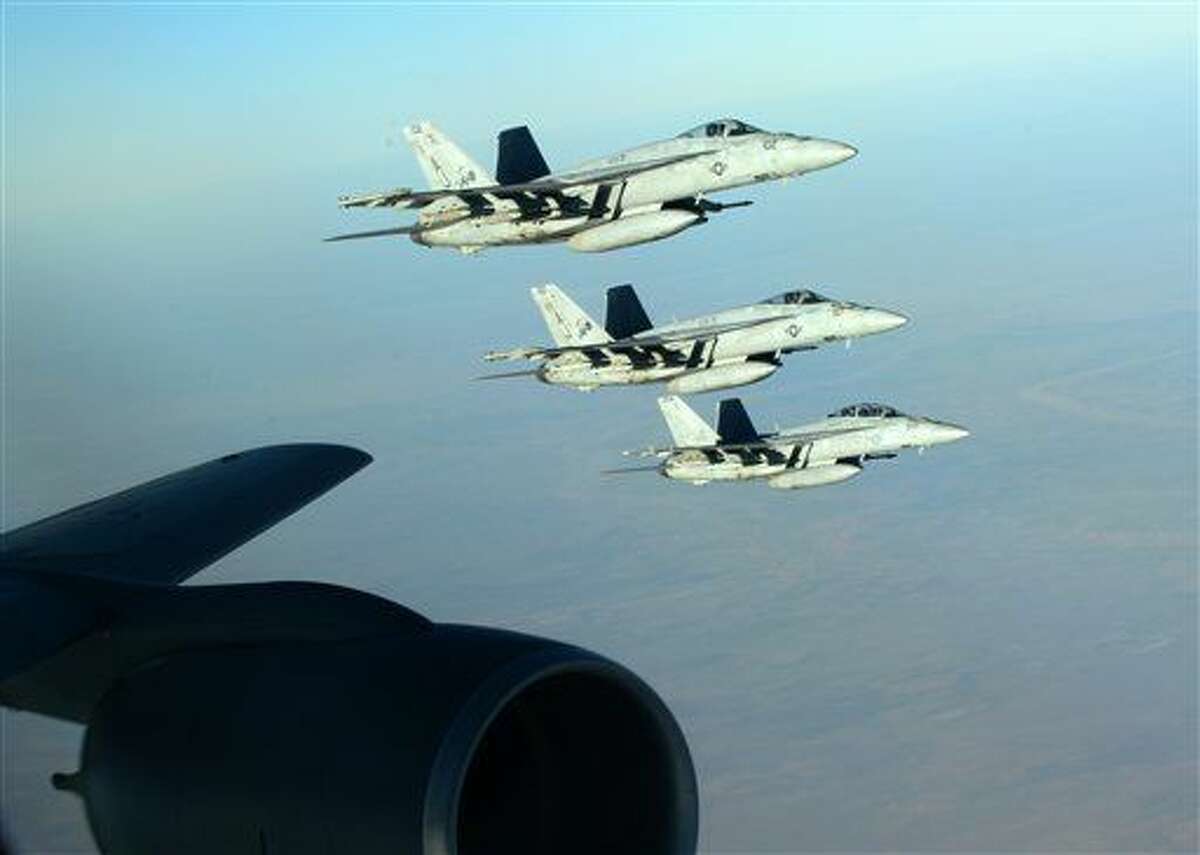 In this Tuesday, Sept. 23, 2014 photo released by the U.S. Air Force, a formation of U.S. Navy F-18E Super Hornets leaves after receiving fuel from a KC-135 Stratotanker over northern Iraq as part of U.S. led coalition airstrikes on the Islamic State group and other targets in Syria. U.S.-led airstrikes targeted Syrian oil installations held by the militant Islamic State group overnight and early Thursday, Sept. 25, 2014, killing nearly 20 people as the militants released dozens of detainees in their de facto capital, fearing further raids, activists said. (AP Photo/U.S. Air Force, Staff Sgt. Shawn Nickel)