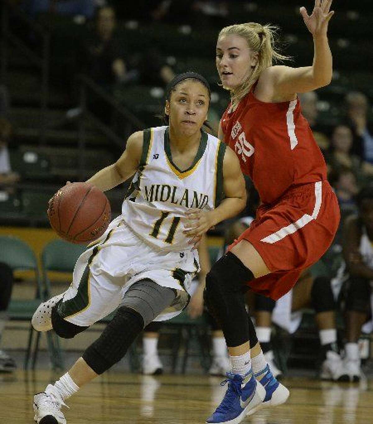 Midland College's Sierra Dixon (11) drives to the hoop past Mesa's Taylor Reed (30) on Thursday, Nov. 19, 2015, at Chaparral Center.