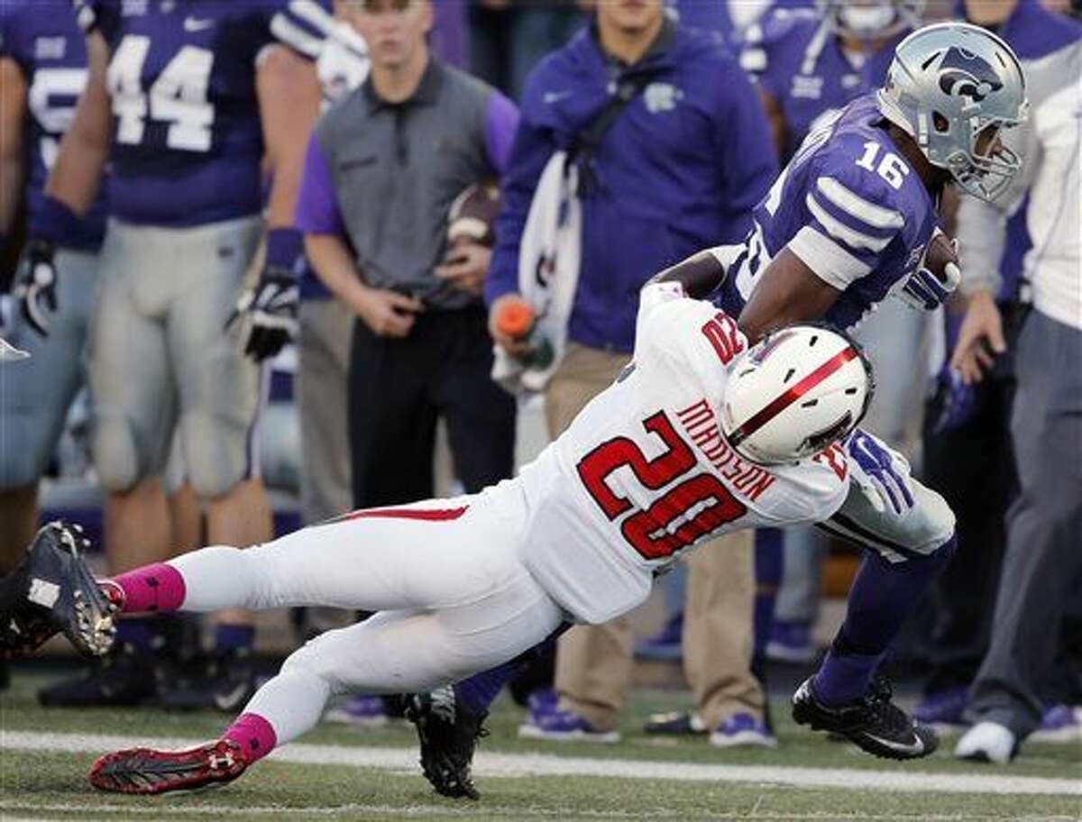 Kansas State wide receiver Tyler Lockett (16) is tackled by Texas Tech defensive back Tevin Madison (20) during the first half of an NCAA college football game in Manhattan, Kan., Saturday, Oct. 4, 2014. (AP Photo/Orlin Wagner)