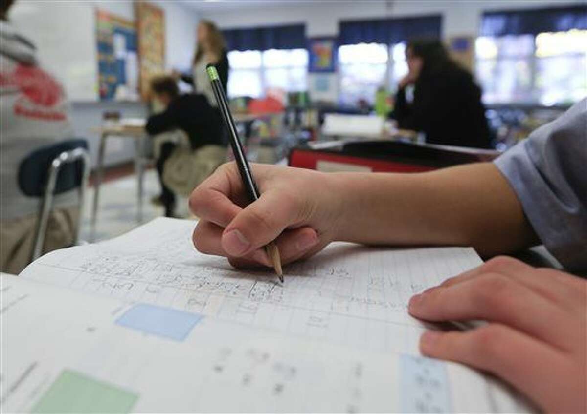 In this Tuesday, Nov. 17, 2015 photo, a student works in an eight grade algebra class at Holy Spirit School in East Greenbush, N.Y. The Diocese of Albany, New York, announced recently that it will reduce the frequency of the Common Core-aligned tests while sticking with the standards. The decision coincides with a call by New York Gov. Andrew Cuomo for “a total reboot” of the Common Core after his state became the epicenter of anti-testing sentiment. (AP Photo/Mike Groll)