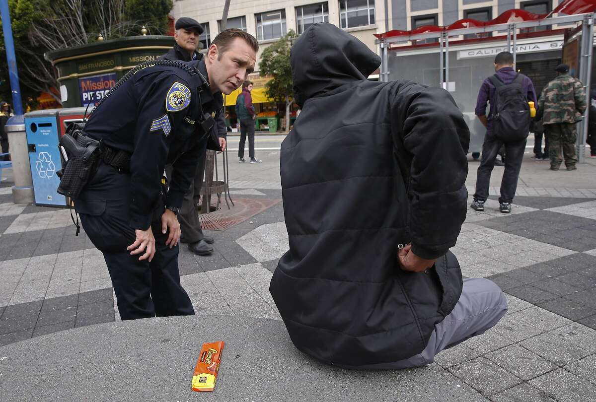 BART Police Sgt. Michael Williamson asks a woman if she needs any assistance on the plaza of the 16th St. BART station in San Francisco, California, on Thurs. May 5, 2016. The SFPD along with BART Police are preparing to launch a new program that will offer those about to be arrested or cited for drug possession the chance to go through a treatment program instead of facing the criminal justice system.