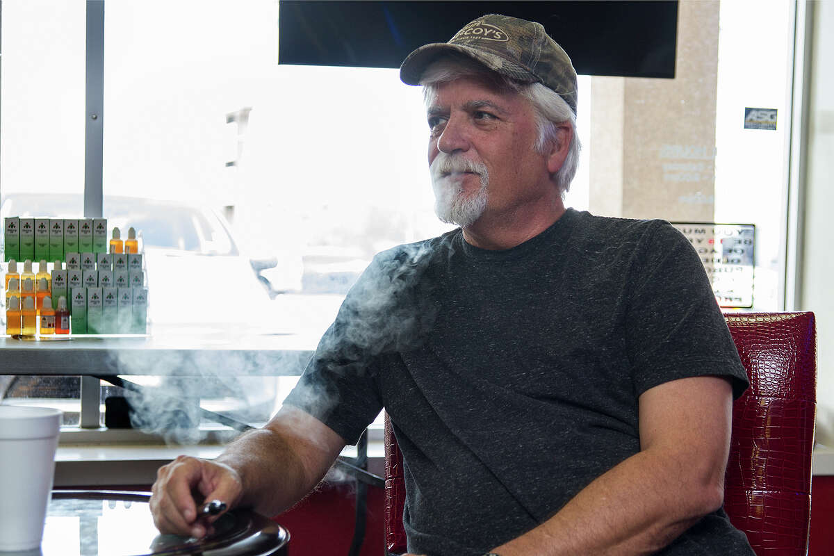 Michael Bolding, a customer at a Thanks for Vaping, smokes an e-cigarette in the store. The Food and Drug Administration has decided to regulate electronic cigarettes like tobacco products .