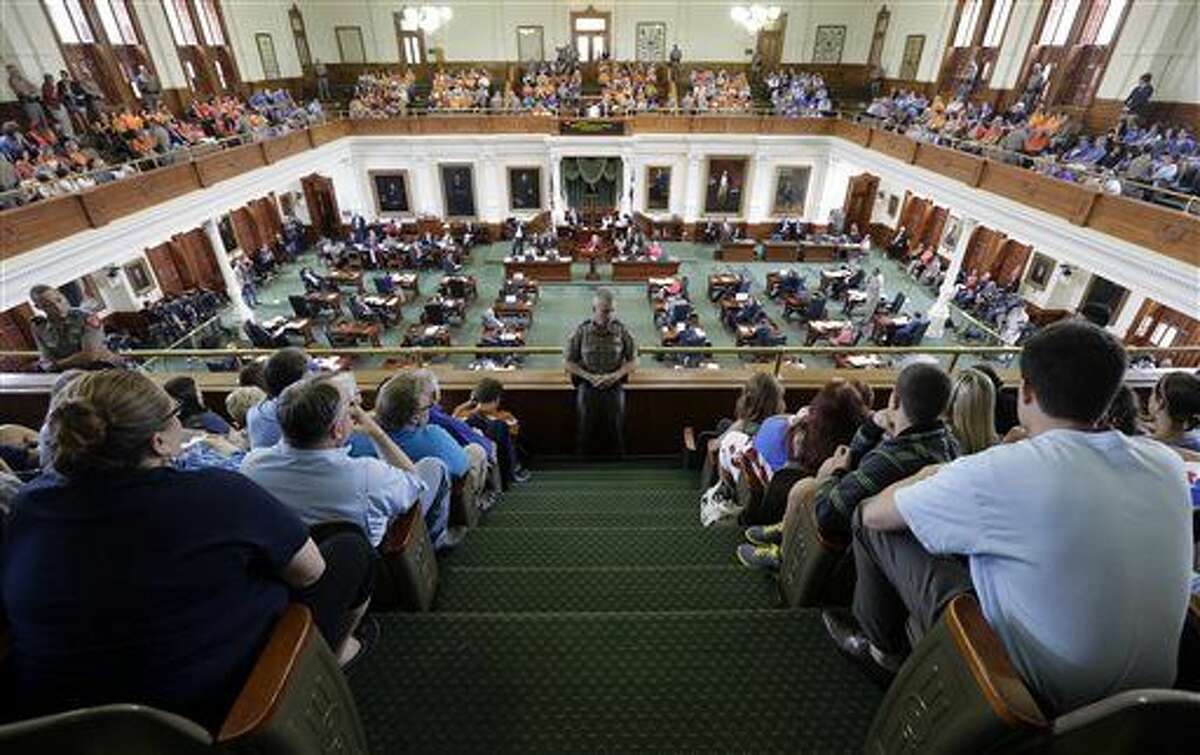 FILE - In this July 12, 2013, file photo, Texas state troopers keep watch as supporters and opponents of an abortion bill, mostly dressed in blue and orange to show their side, sit in the gallery of the Texas Senate chambers as lawmakers debate before the final vote, in Austin, Texas. Will the Texas Senate’s majority Republicans tweak chamber tradition to keep the Democrats from blocking the hottest-button bills? The start of Texas’ 140-day legislative session on Tuesday, Jan. 13, 2015, may bring clarity to some burning questions, but it’s also sure to raise more than it answers. (AP Photo/Eric Gay, File)