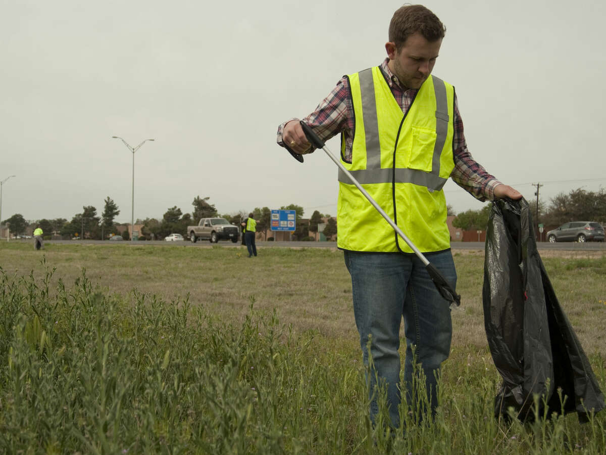 Tim Hair and other KMB board members clean up trash along Loop 250 Tuesday, 3-31-15, on the southside service road. Tim Fischer\Reporter-Telegram