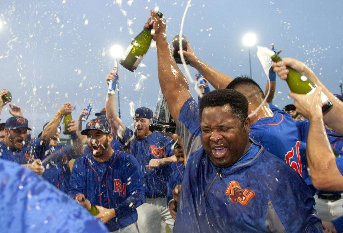 Rockhounds hitting coach Webster Garrison hoists a champaign bottle while team members celebrate a 5-0 win over Tulsa in the final game of the Texas League Championship series Sunday at Security Bank Ballpark. James Durbin/Reporter-Telegram