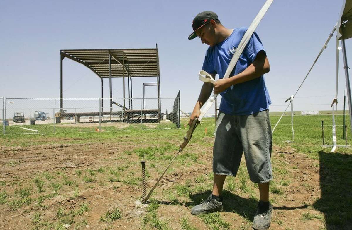 Francisco Trejo, with Dallas Party Tent and Event, erects a tent Wednesday afternoon during preparations for CrudeFest. Cindeka Nealy/Reporter-Telegram