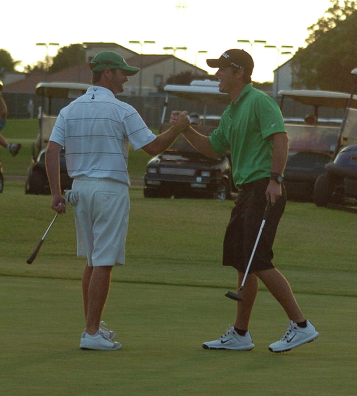 Bobby Whiteside, left, and K.T. Livingston, right, celebrate after Whiteside sank a putt for eagle on the 18th hole of the Jamboree at Green Tree Country Club in 2012. Photo by Len Hayward