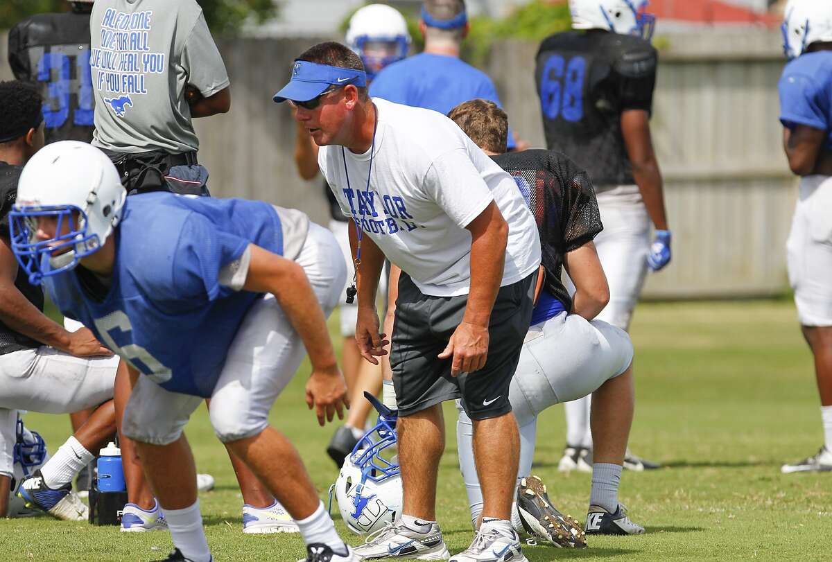 Katy Taylor head football coach Trey Herrmann works with the defense as the Mustangs went through regular practice drills on August 4, 2014.