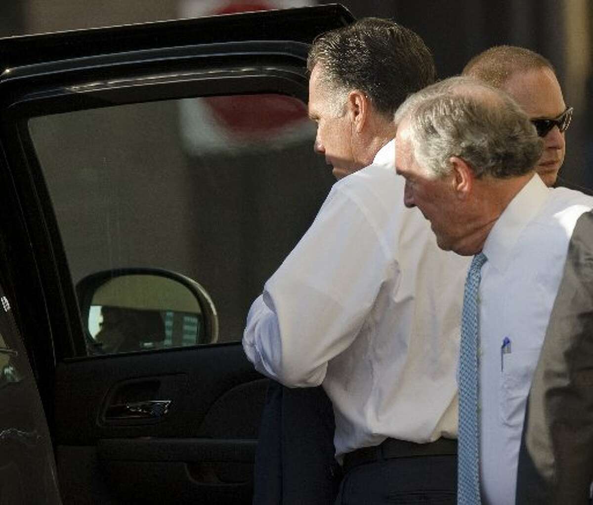 Gov. Mitt Romney gets back into his car after a fundraising event at the Petroleum Club. Midlander Don Evans, at right, was traveling with the presidential candidate. 