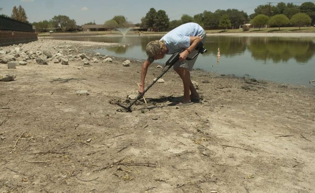 FILE - Tom Byrom uses a metal detector in this 2011 file photo to search for lost treasures along the dried up banks of Wadley Barron Pond. Photo by Tim Fischer/Midland Reporter-Telegram
