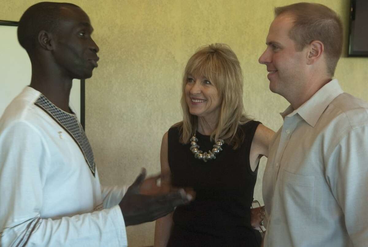 Ronald Ongopa, Habitat Uganda, talks with Alynda Best, Midland director of Habitat and Jacob Hooper, Midland board president, during a luncheon Tuesday at Ranchland Hills Country Club.