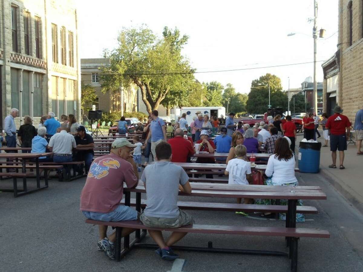 People gather to eat at picnic tables in Winfield, Kan., during the annual Walnut Valley Festival.