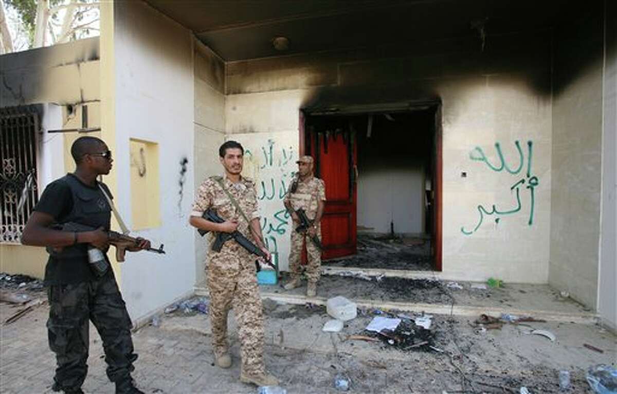 FILE - In this Sept. 14, 2012 file photo, Libyan military guards check one of the burnt out buildings at the U.S. Consulate in Benghazi, Libya, during a visit by Libyan President Mohammed el-Megarif to express sympathy for the death of American ambassador to Libya Chris Stevens and his colleagues in the Sept. 11, 2012 attack on the consulate. The White House has put special operations strike forces on standby and moved drones into the skies above Africa, ready to strike militant targets from Libya to Mali — if investigators can find the al-Qaida-linked group responsible for the attack. (AP Photo/Mohammad Hannon, File)