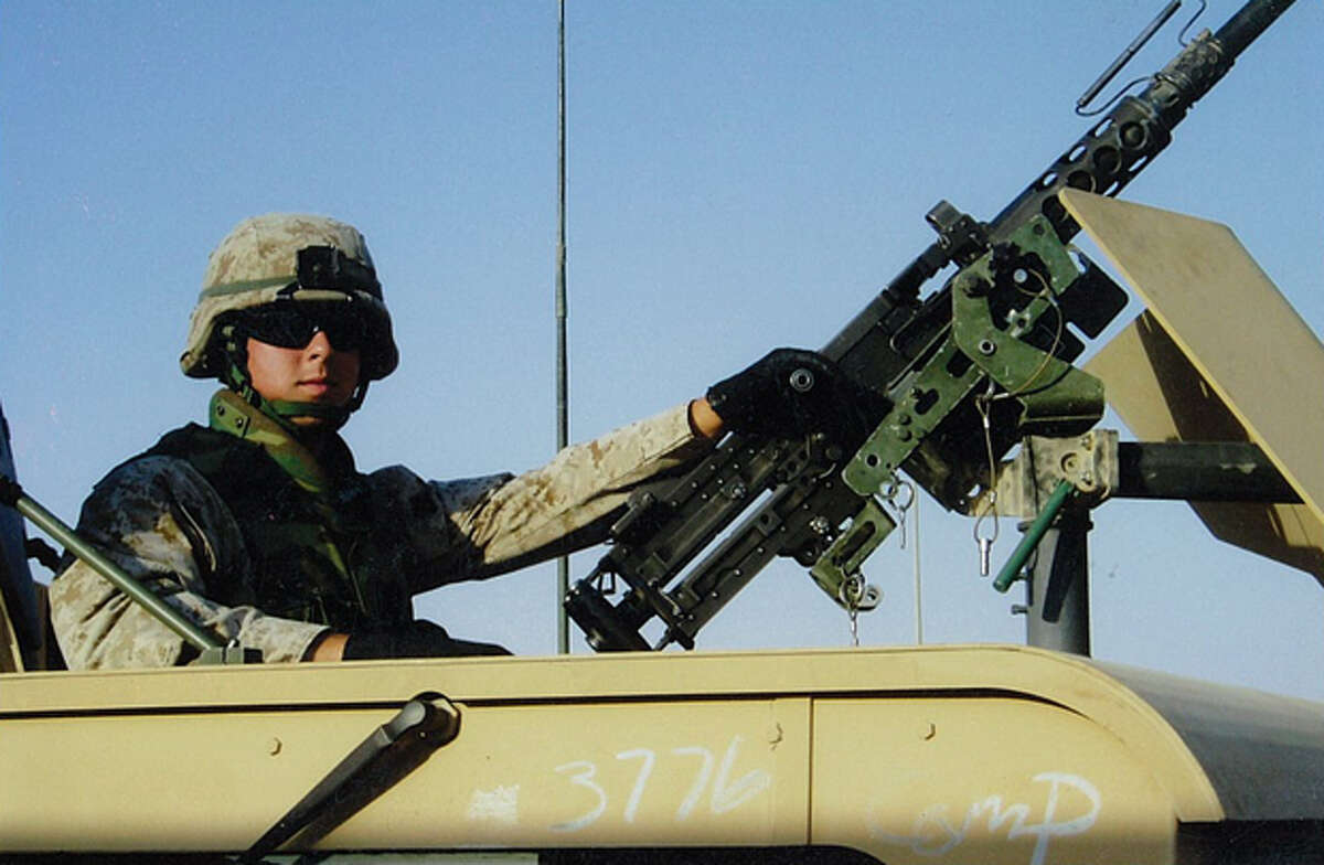 Sgt. Ben Ryburn, who returned to Midland to become a landman, poses next to a .50-caliber gun.