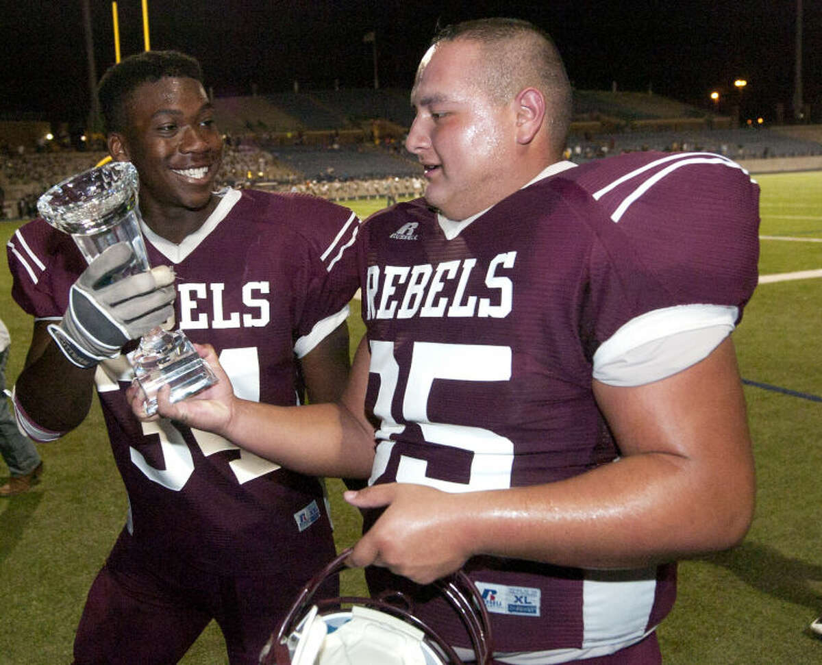 Lee High's Relandas Swan (34) and Vincent Machuca (95) hold the game trophy after a win against EP Coronado Friday at Grande Communications Stadium. James Durbin/Reporter-Telegram
