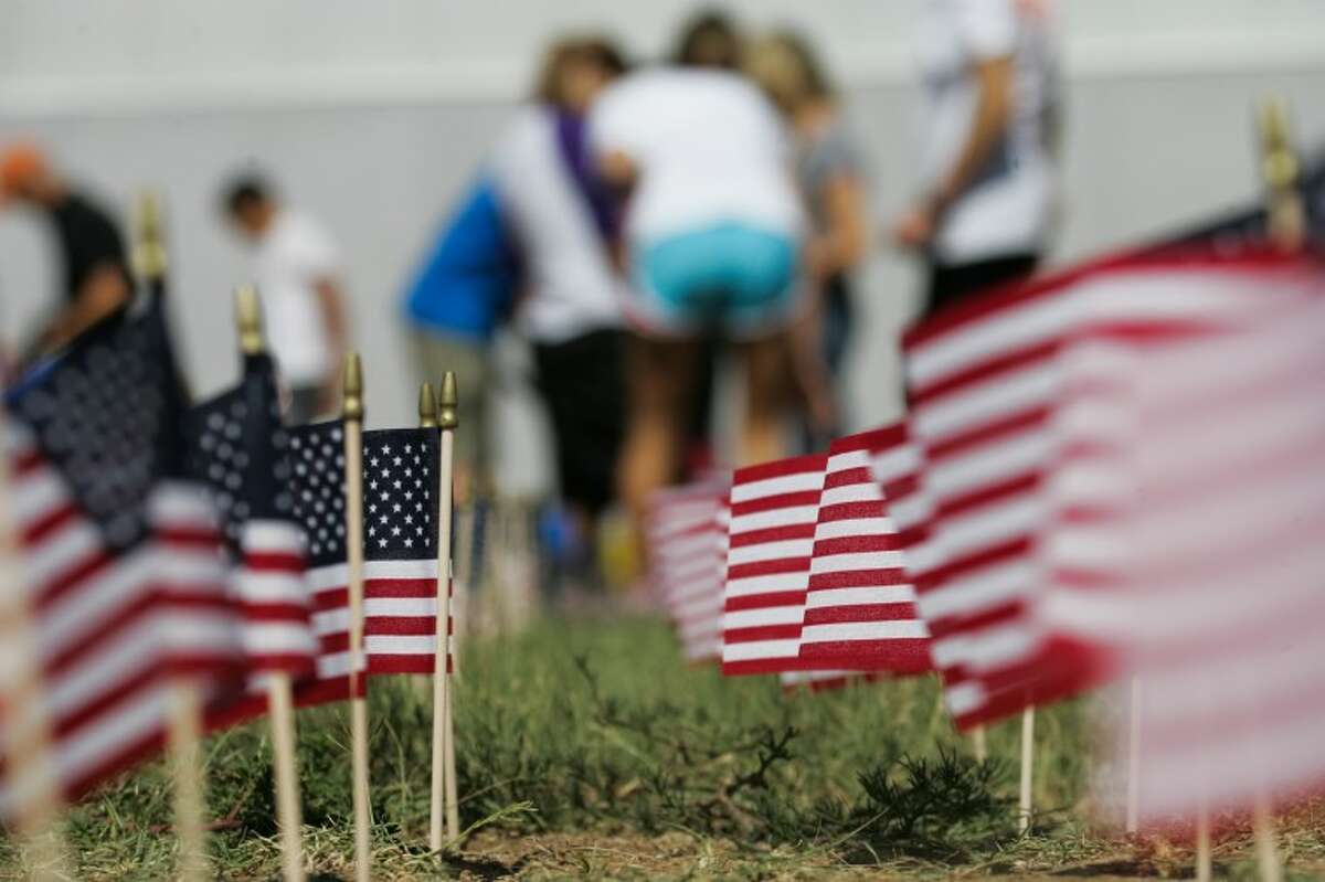 A finished row of flags stands erect Monday as volunteers work to complete the temporary memorial at Midland Classical Academy for the 2,978 victims of the 9/11 attacks.