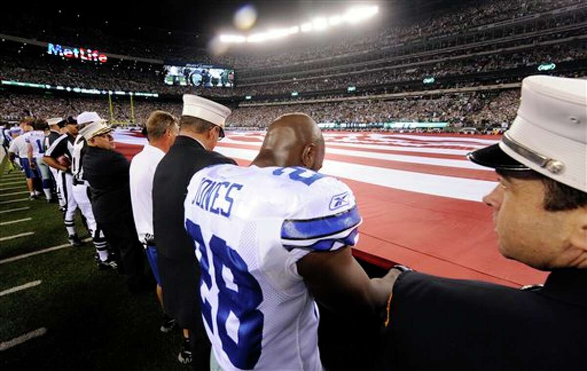Dallas Cowboys running back Felix Jones (28) holds an American flag with first responders during the national anthem before an NFL football game between the Dallas Cowboys and New York Jets, Sunday, Sept. 11, 2011, in East Rutherford, N.J. (AP Photo/Henny Ray Abrams)