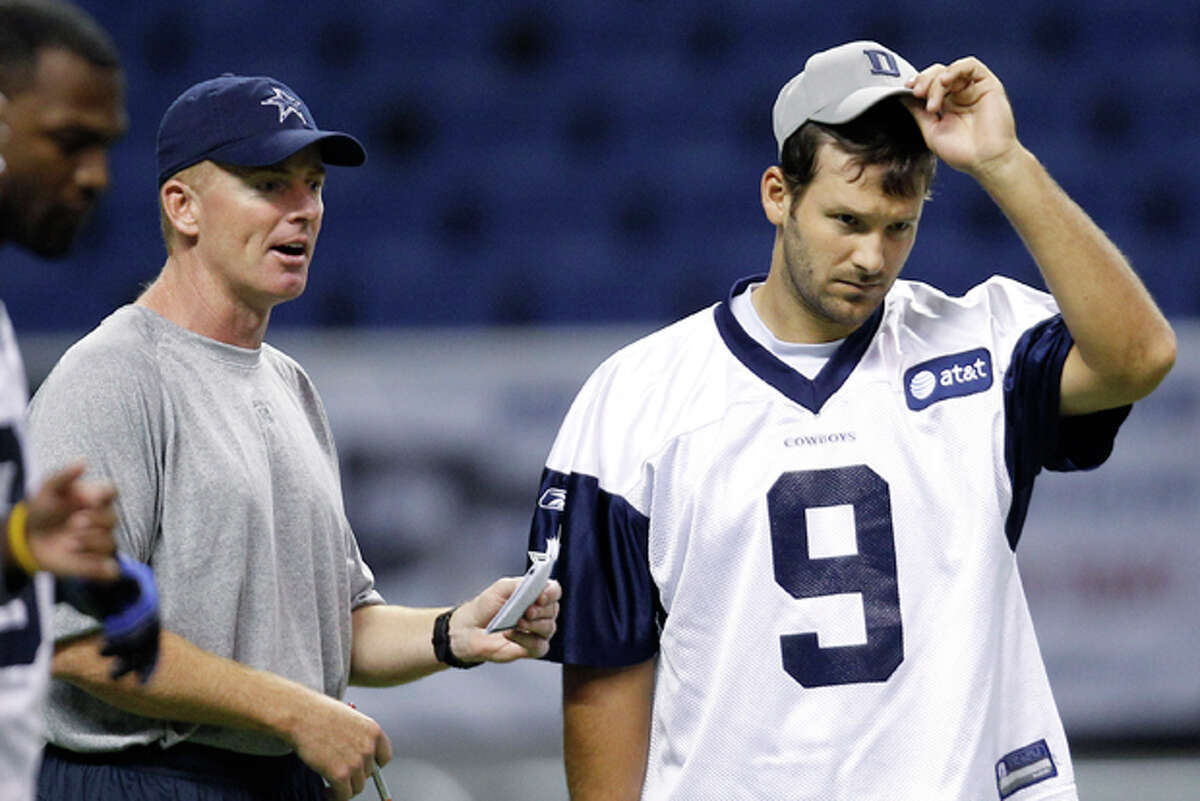 FILE - This July 29, 2011, file photo shows Dallas Cowboys coach Jason Garrett, left, talking with Tony Romo (9) during an NFL training camp walk through, in San Antonio. Garrett says Romo looks "as normal as he can be," a good sign indeed for the Cowboys. (AP Photo/Eric Gay, File)