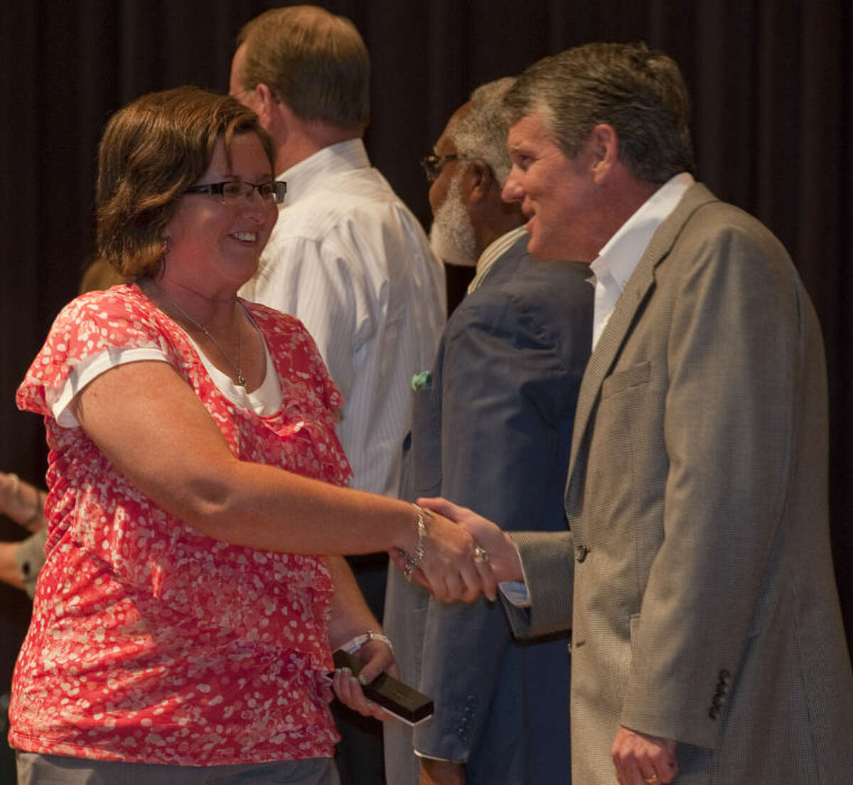 Amy Buchanan, teacher at Sam Houston, shakes hands with MISD board president Rick Davis Monday evening as she and other MISD employees are recognized for their years of service to the district. Tim Fischer\Reporter-Telegram