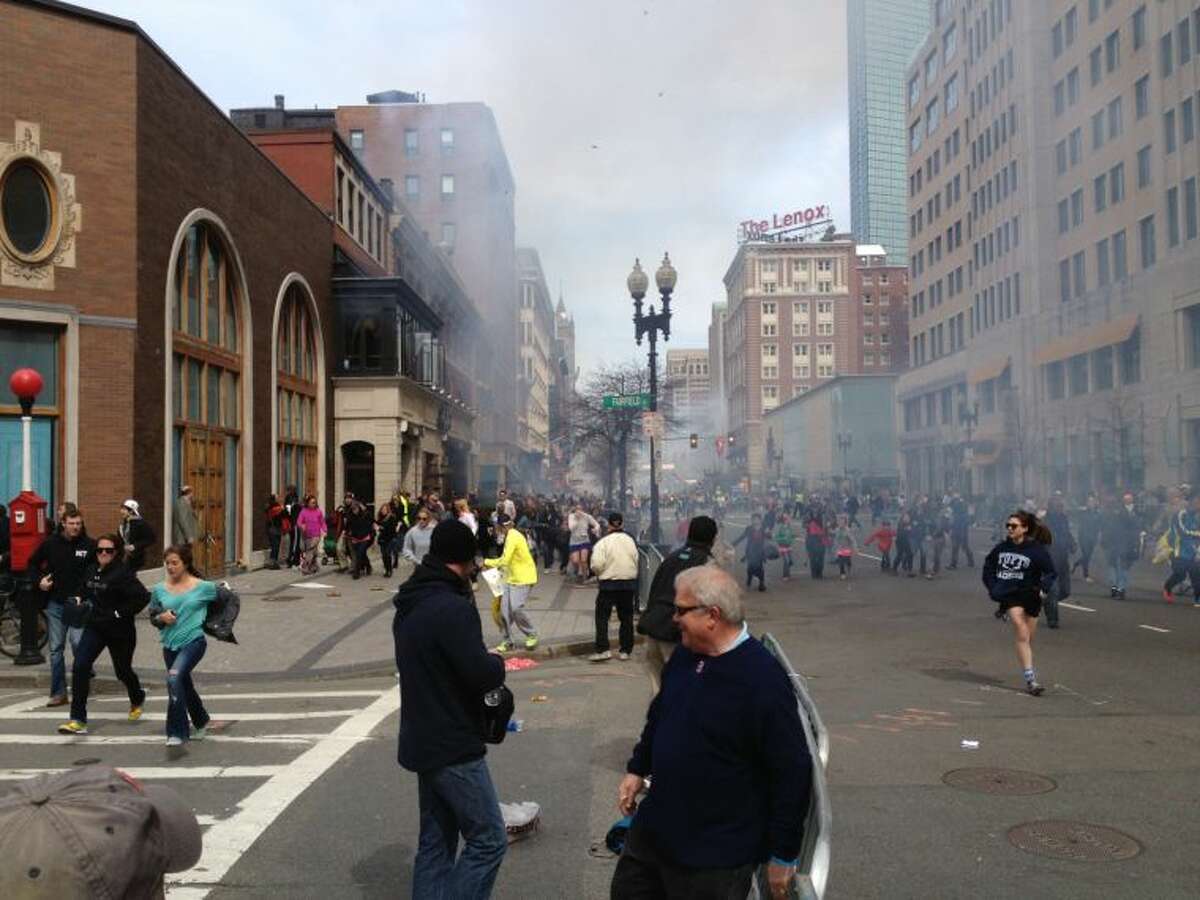 This Monday, April 15, 2013 photo shows a man who was dubbed Suspect No. 2 in the Boston Marathon bombings by law enforcement, on the left side of the frame, wearing a white baseball cap, walking away from the scene of the explosions. The FBI identified him as 19-year-old college student Dzhokhar Tsarnaev, who along with his brother Tamerlan, 26, previously known as Suspect No. 1, killed an MIT police officer, severely wounded another lawman and hurled explosives at police in a car chase and gun battle during a night of violence, early Friday, April 19, 2013. Tamerlan Tsarnaev was killed overnight, officials said, while his brother Dzhokhar remains at large. (AP Photo/David Green) EXCLUSIVE CONTENT-SPECIAL RATES APPLY FOR NON-AP MEMBERS AND SUBSCRIBERS.