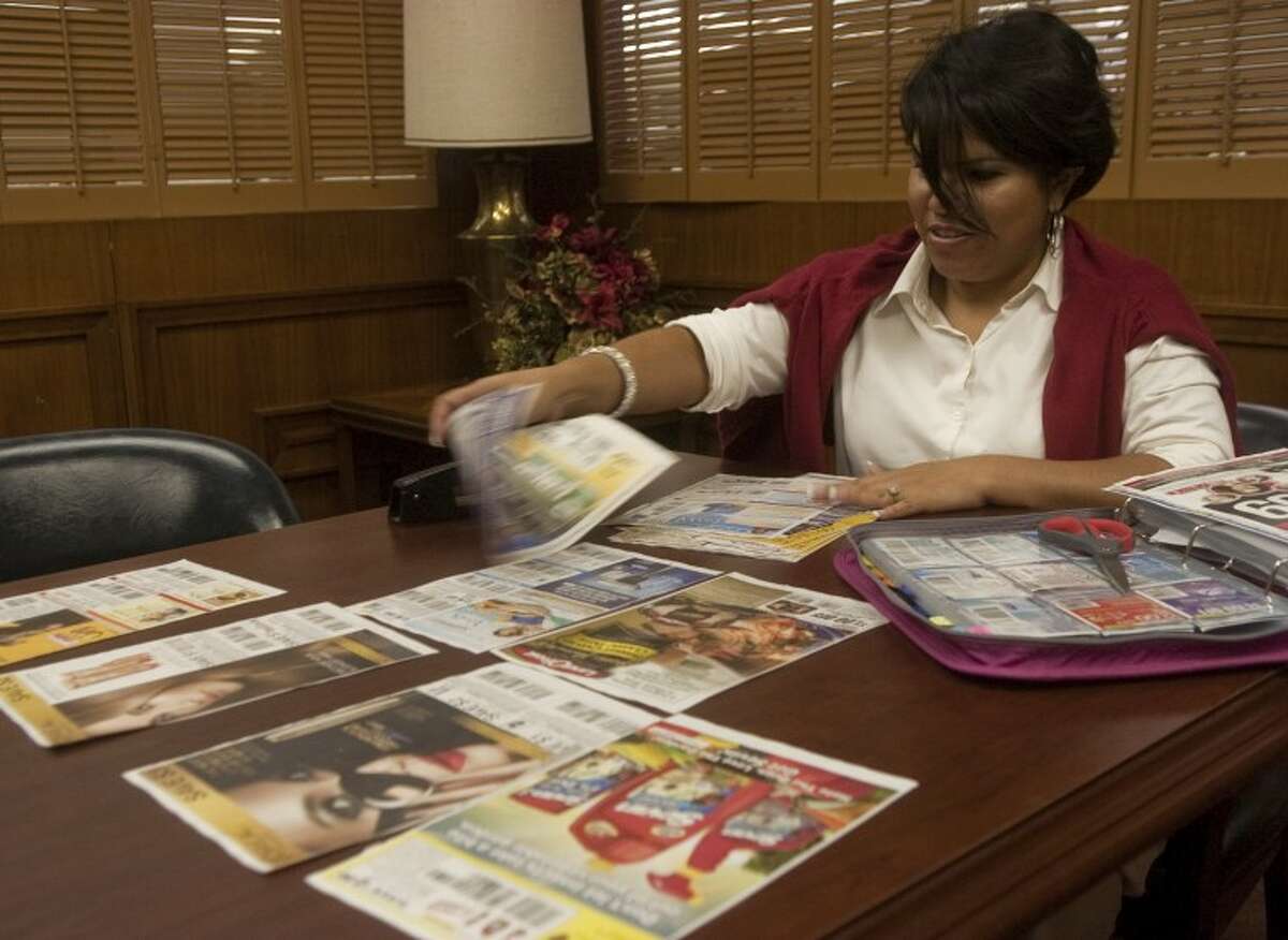 Celestine Lunda buys four Sunday papers to get the extra coupons in the inserts and then rips each page of coupon out to place in a pile together. Photo by Tim Fischer/Midland Reporter-Telegram
