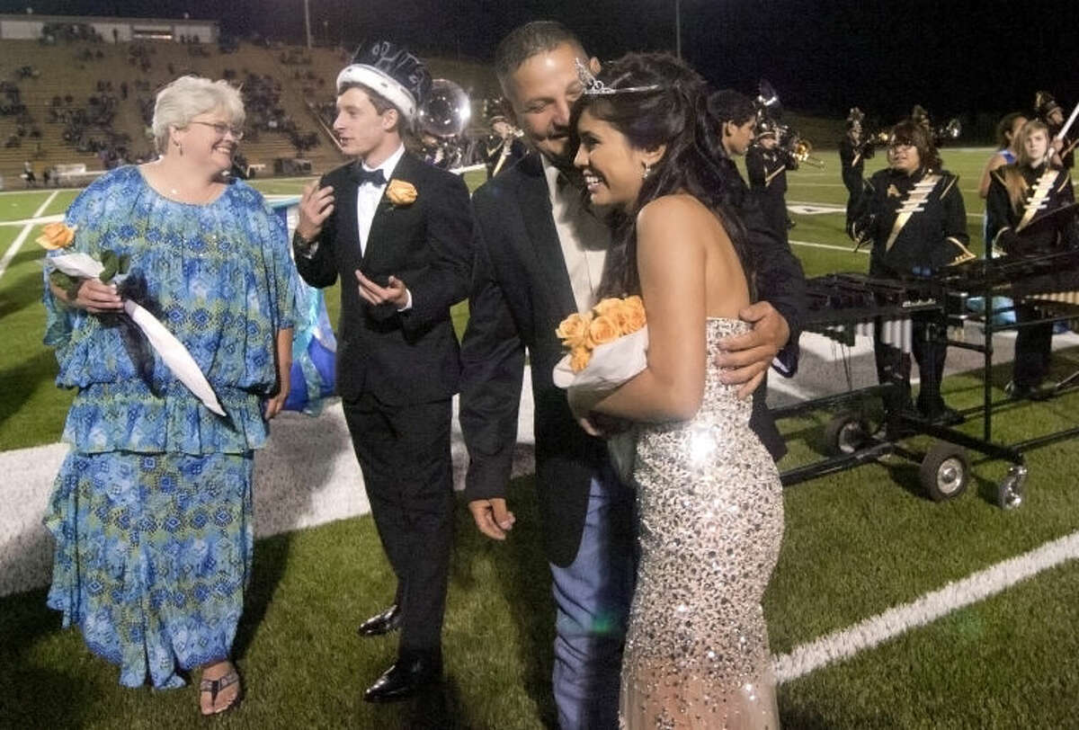 Ashley Lujan gets a hug from her father and Hunter Hicks talks with his mother after the two were crowned homecoming queen and king during the Andrews Homecoming game against Big Spring on Friday at Mustang Bowl. James Durbin/Reporter-Telegram