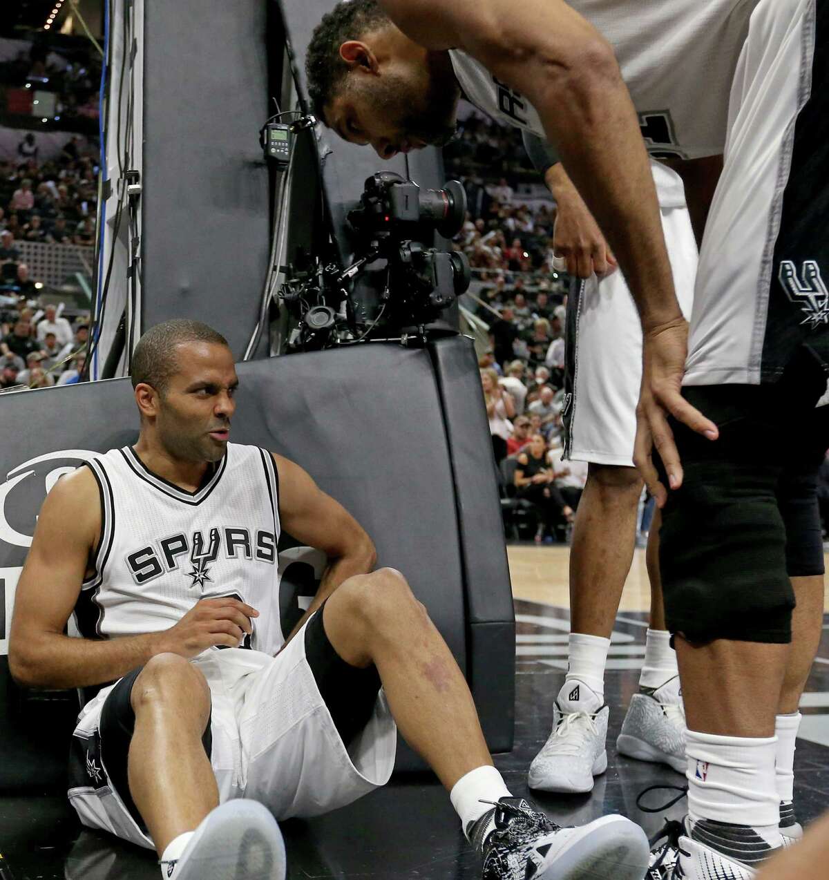 San Antonio Spurs' Tony Parker sits on the court as Tim Duncan looks on after being injured on a play by Oklahoma City Thunder's Russell Westbrook during first half action of Game 5 in the Western Conference semifinals Tuesday May 10, 2016 at the AT&T Center.