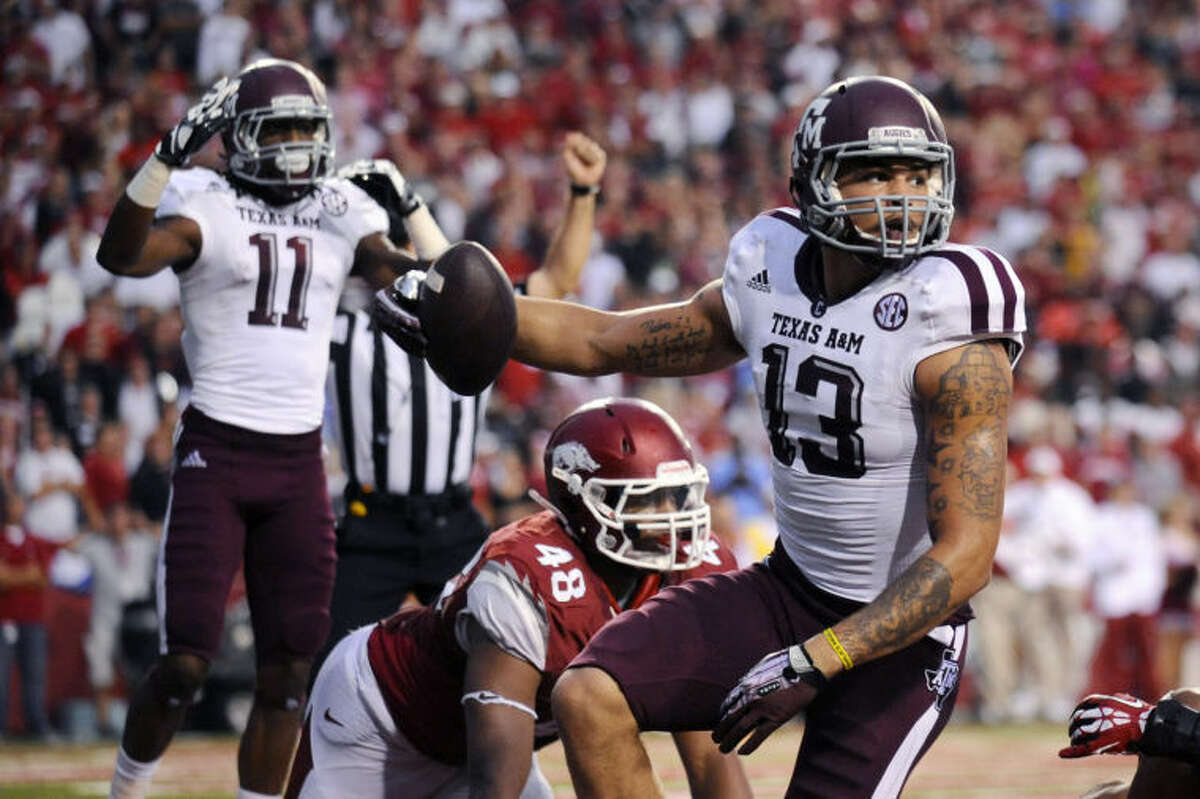 Texas A&M wide receiver Mike Evans (13) and wide receiver Derel Walker (11) celebrate Evans' touchdown over Arkansas defensive end Deatrich Wise Jr. (48) during the seconod quarter of an NCAA college football game in Fayetteville, Ark., Saturday, Sept. 28, 2013. (AP Photo/Beth Hall)