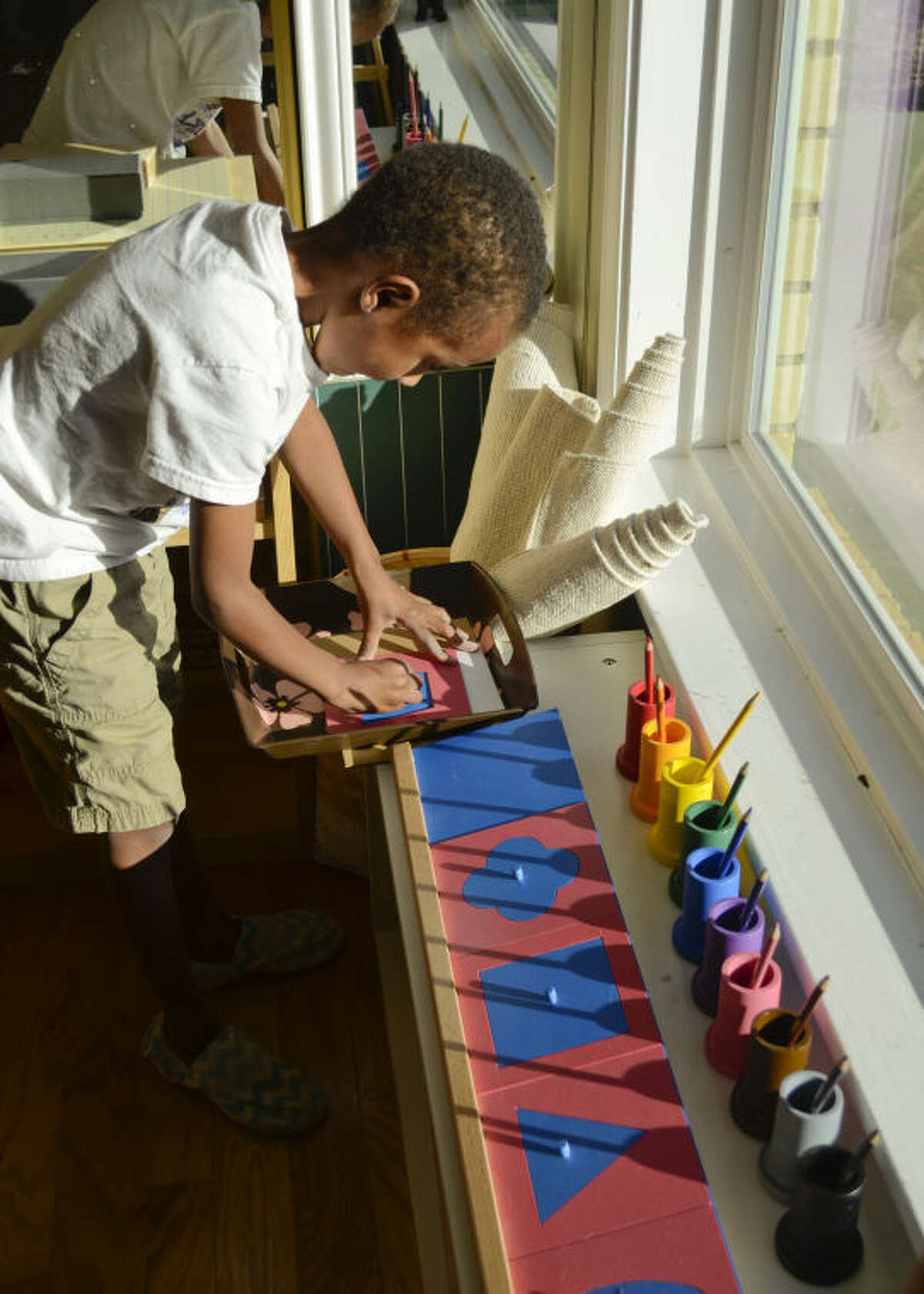 David Mugoya picks out shapes to draw Monday at Young Blossm Montessori School. Tim Fischer\Reporter-Telegram